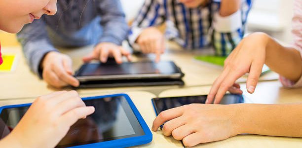 close up of school kids playing with tablet pc