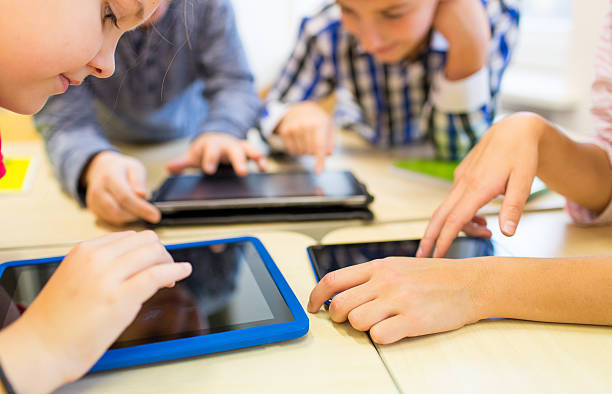 close up of school kids playing with tablet pc