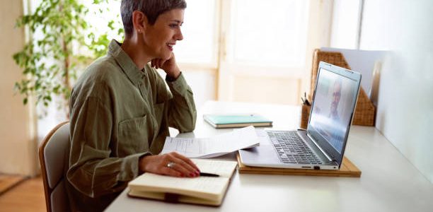 woman following online courses on her laptop at home