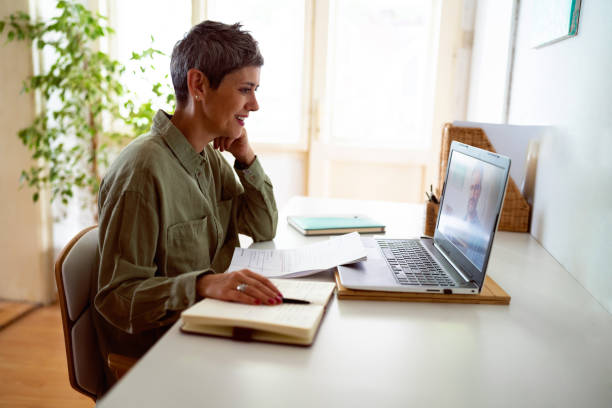 woman following online courses on her laptop at home
