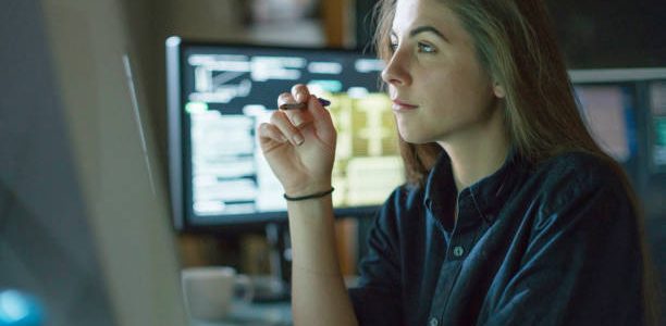 woman monitors dark office