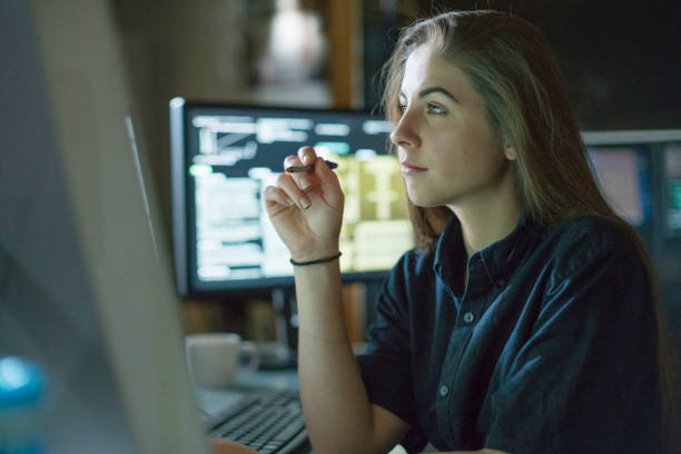 woman monitors dark office